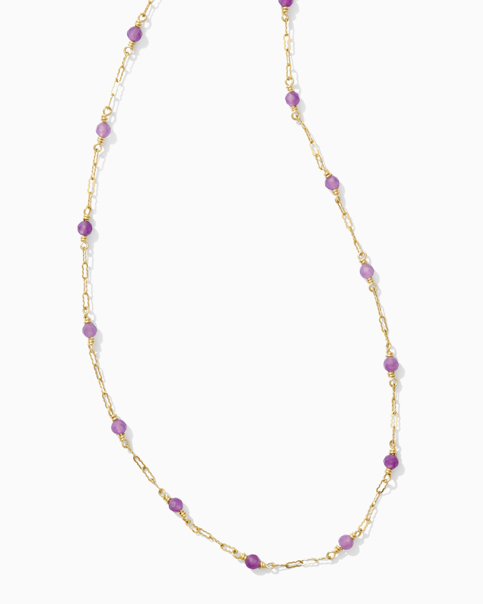 Gold necklace with purple beads on a white background.
