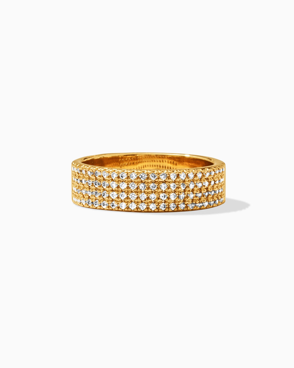A display of a gold ring with four tracks that is embedded by cubic zirconia all around the ring on a white background.