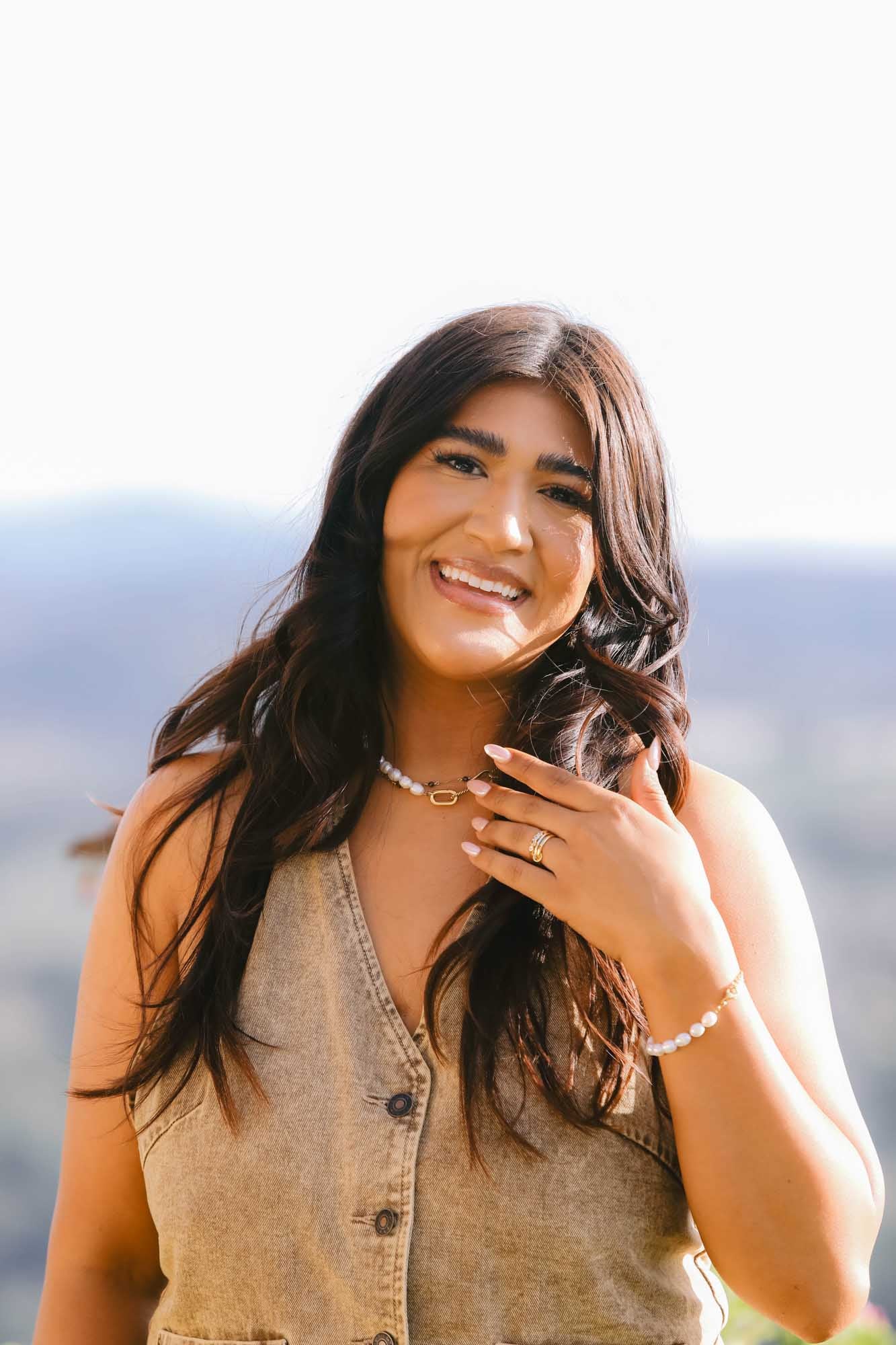 Woman on blurred background wearing pearl necklace, pearl bracelet and gold ring