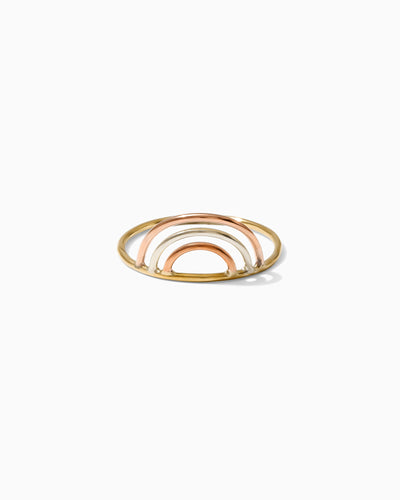 A gold ring with a rainbow design made of rose gold and silver on a white background.